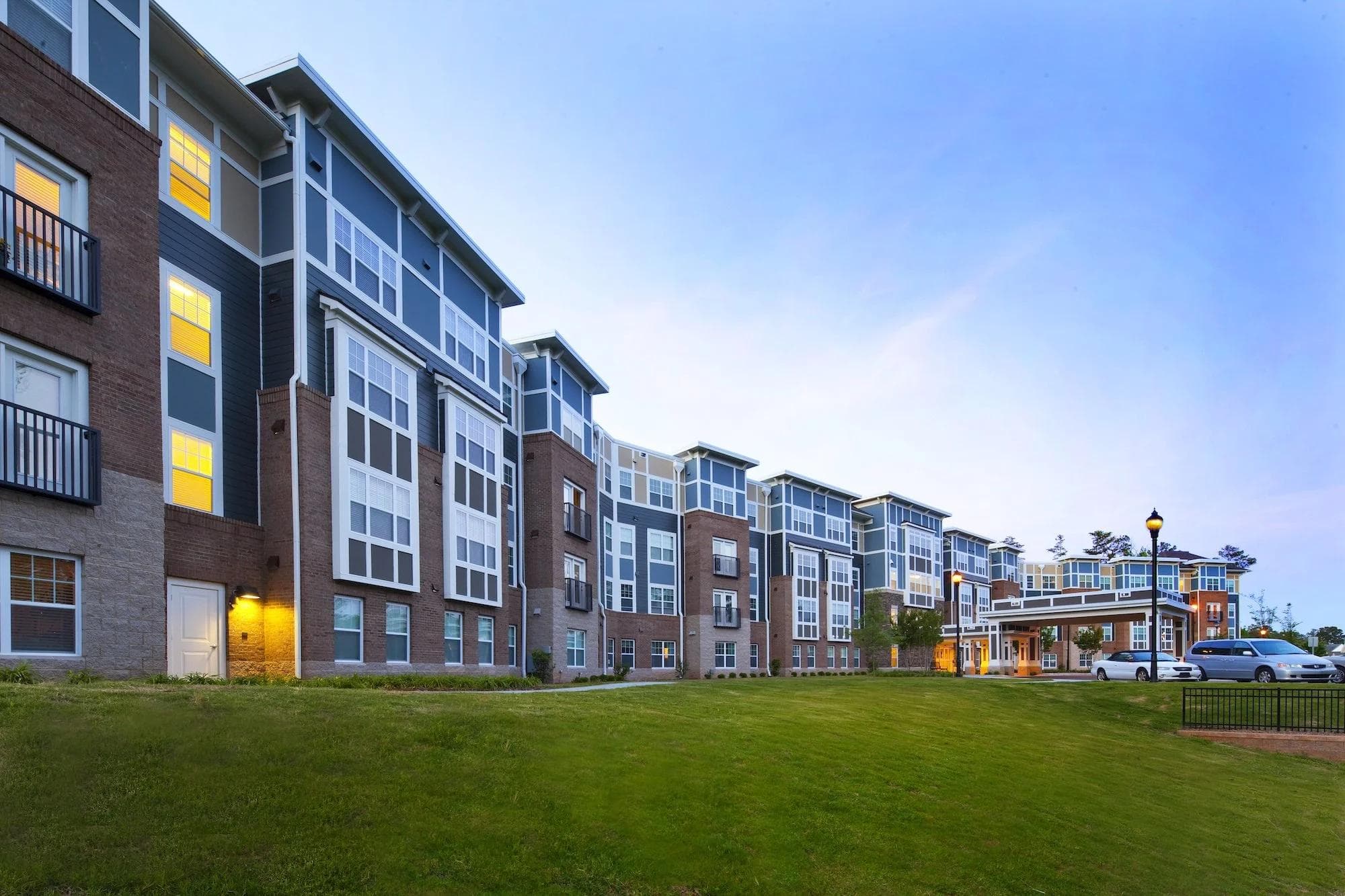 Multifamily apartment community exterior at dusk
